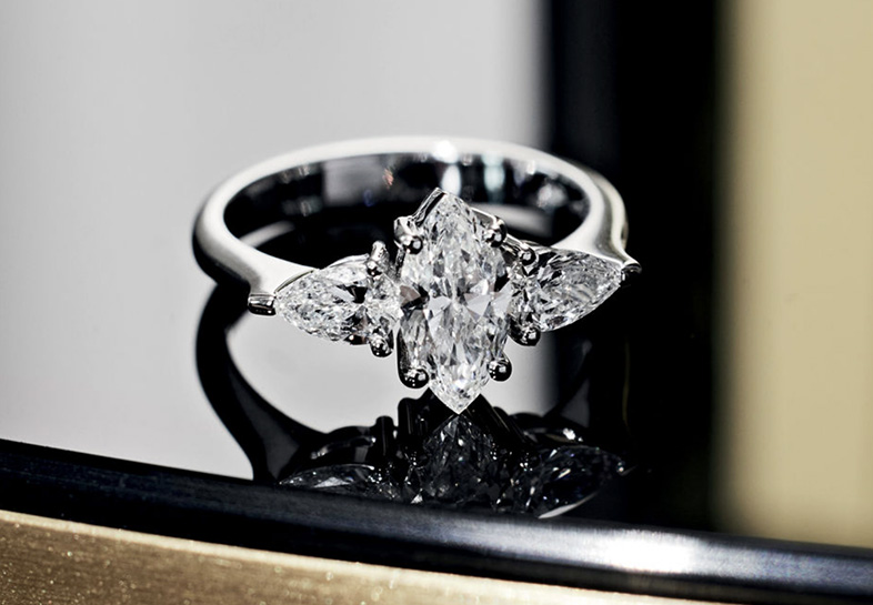 anello con diamante taglio navette e contorno di 2 diamanti a goccia